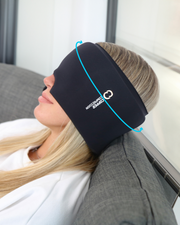 Copper Compression CopperFreeze Migraine Mask, a woman lying on a sofa with the mask pushed up on her forehead