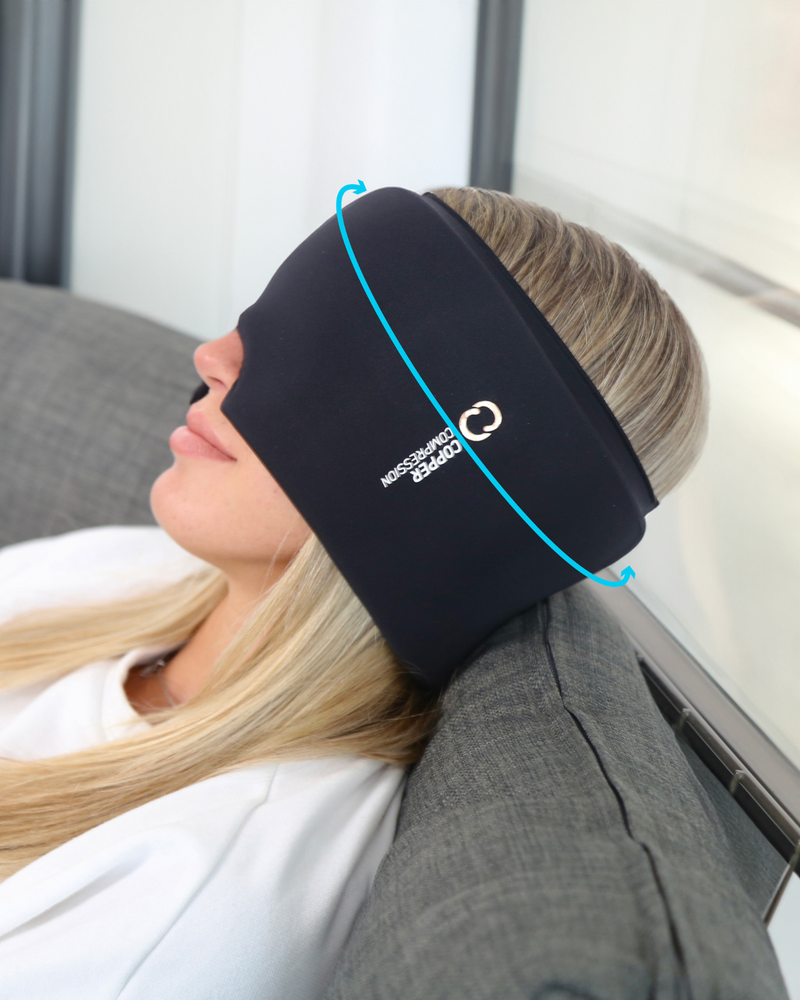 Copper Compression CopperFreeze Migraine Mask, a woman lying on a sofa with the mask pushed up on her forehead