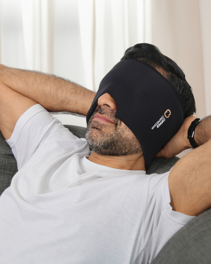Copper Compression CopperFreeze Migraine Mask, a man lying down wearing the mask over his eyes