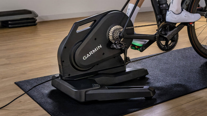Garmin Tacx Nera on a mat at home, a rider's foot on the pedal