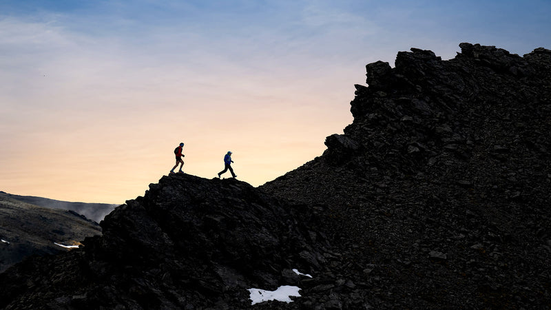 Garmin Enduro 4, two trail runners crossing a ridge at dusk