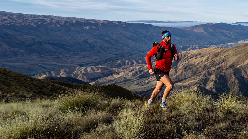 Garmin Enduro 4, trail runner climbing a grassy mountain ridge