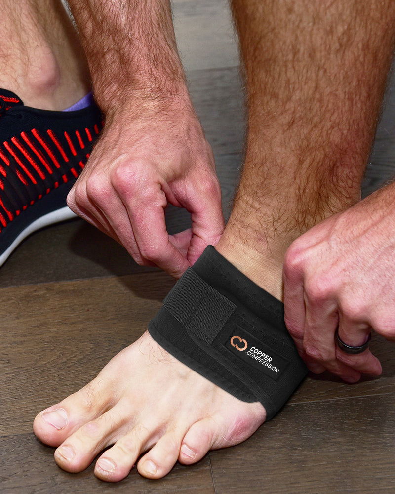 Copper Compression Arch Support Sleeves, hands fastening an adjustable arch support onto a foot