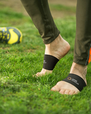 Copper Compression Arch Support Sleeves, bare feet in black arch supports on a soccer pitch