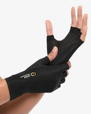 Copper Compression Half Finger Gloves, the black gloves worn on a pair of hands against a white background