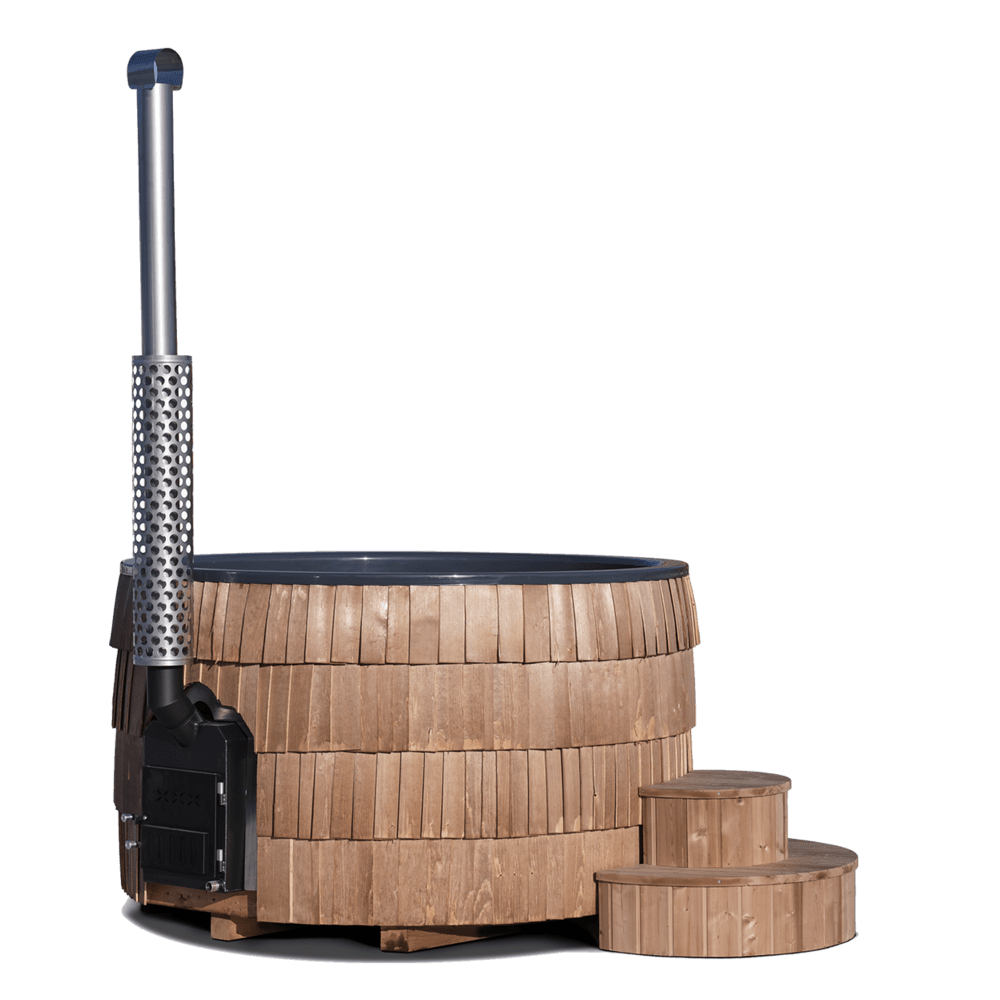 Iglucraft Wood-Burning Hot Tub in Chestnut finish — side view showing the cylindrical wooden shingled exterior, the stainless steel wood-fired stove and perforated chimney heat shield on the left, and two matching round wooden steps on the right