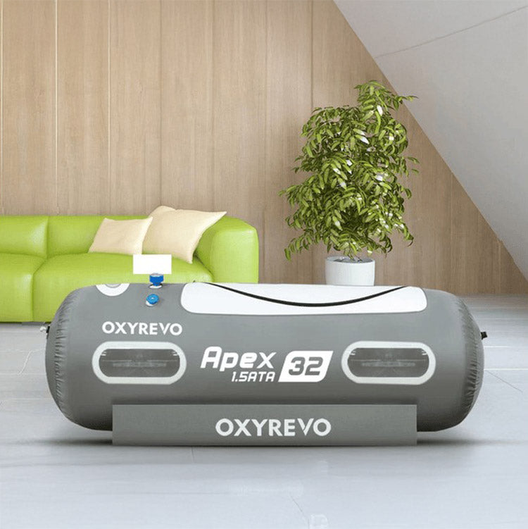 OxyRevo Apex32 hyperbaric chamber inflated in a bright living room beside a green sofa and a plant