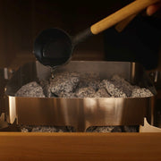 Homecraft Revive sauna heater with water ladled onto its stones