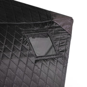 Close-up of the quilted tent fabric with the window panel rolled up and held by its strap