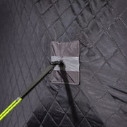 Guy line and stake anchoring a corner of the quilted skirt