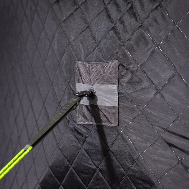Guy line and stake anchoring a corner of the quilted skirt