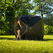 Woman walking away from the erected tent on grass