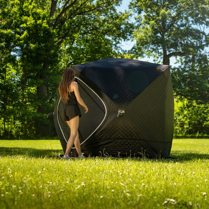 Woman walking away from the erected tent on grass