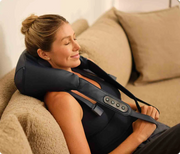 Therabody ThermNeck & Upper Back worn reclined on a couch