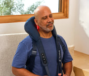 Therabody ThermNeck & Upper Back worn in a chair at home