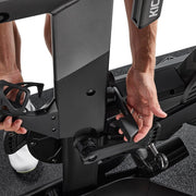 Wahoo KICKR BIKE PRO, hands adjusting the frame near the base