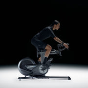 Wahoo KICKR BIKE SHIFT, rider in dark kit pedalling against a black backdrop