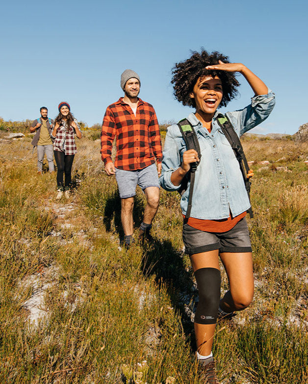 Copper Compression Knee Sleeve, three people hiking outdoors, one wearing the knee sleeve
