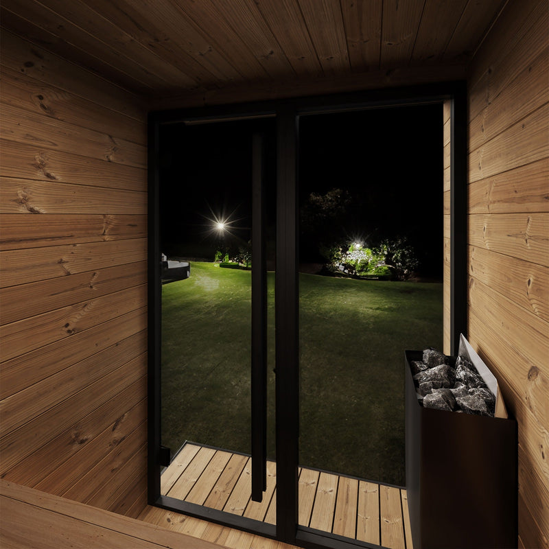SaunaLife GL4 4-Person Outdoor Traditional Sauna - interior heater with glass front view at night