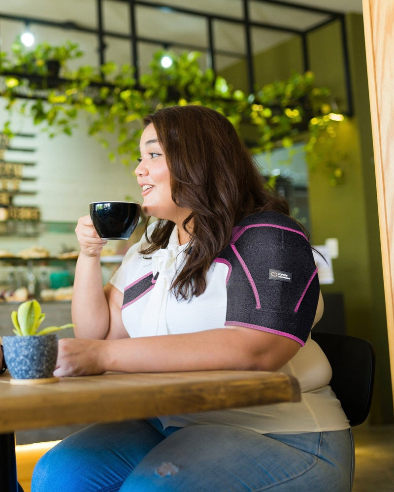 Copper Compression Shoulder Brace, the pink shoulder brace worn on a shoulder